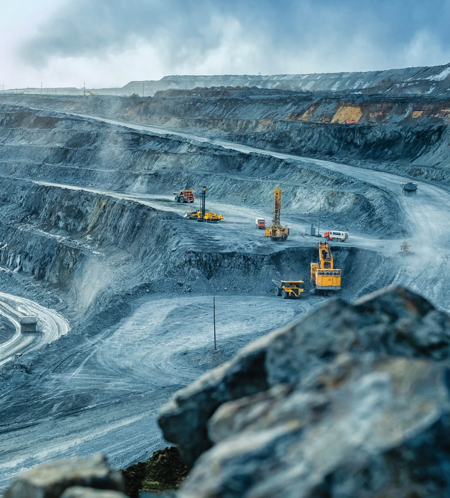 Work of trucks and the excavator in an open pit on gold mining, soft focus